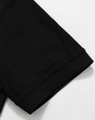 A black Men's Truedry Pique Polo shirt showcasing the sleeve detail. The shirt features a logo.