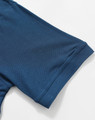 A close-up of a blue polo shirt sleeve with a smooth texture and cuff detail, featuring a logo.