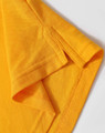 A close-up of a folded yellow polo shirt, highlighting the collar and sleeve details. The fabric appears textured and vibrant.