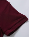 A maroon polo shirt featuring a classic pique texture and a logo on the sleeve.