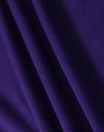 A close-up of purple fabric with a textured surface, showing folds and the material's weave.