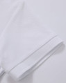 A white polo shirt featuring a textured fabric and a folded sleeve detail. It includes a logo.
