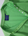 A green Ladies' Truedry Pique Polo shirt features a polo collar and button detail, with a brand label visible.