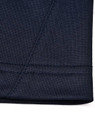 A close-up of the hem of a navy polo shirt showcasing the fabric texture and stitching detail.