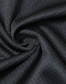 A close-up of black jacquard knit fabric featuring a textured pattern, suitable for a polo shirt.