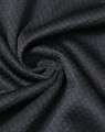 A close-up of a black jacquard knit fabric, showcasing its textured pattern and soft material.