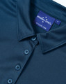 A dark blue sustainable jacquard knit short sleeve polo with a button-up collar and a branded label.