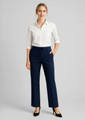 A woman poses in navy adjustable waist pants paired with a white shirt and heels, featuring a logo on the waistband.