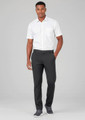 A man wearing black flat front slacks paired with a white short-sleeve shirt and grey sneakers. There is a logo on the slacks.