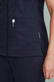 A navy blue women's scrub top featuring zip front closure and pockets, with a stylish design and branding.