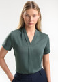 A short-sleeve button-up shirt in a soft green colour, featuring a v-neck design and a subtle front pleat.