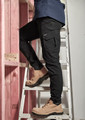 Men's lightweight outdoor cargo pants in black, featuring multiple pockets, worn while climbing a ladder.