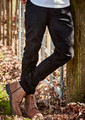 Black stretch jeans with a slim fit, paired with brown boots, set against a natural outdoor background.