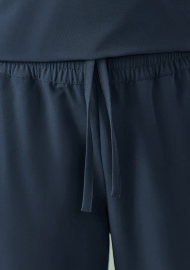 A pair of navy unisex scrub pants with an elastic waistband and drawstring detail. Features a logo.