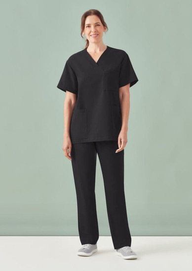 Unisex Pulse Straight Leg Scrub Pant in black, paired with a matching black scrub top, model standing against a green background.