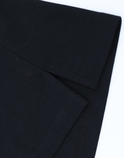 A black cotton/poly pique polo shirt showcasing the folded collar and sleeve detail. It has a logo on the fabric.