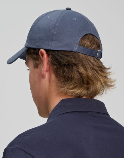 A cotton twill unstructured cap in navy blue, featuring a adjustable strap and a branding detail at the back.