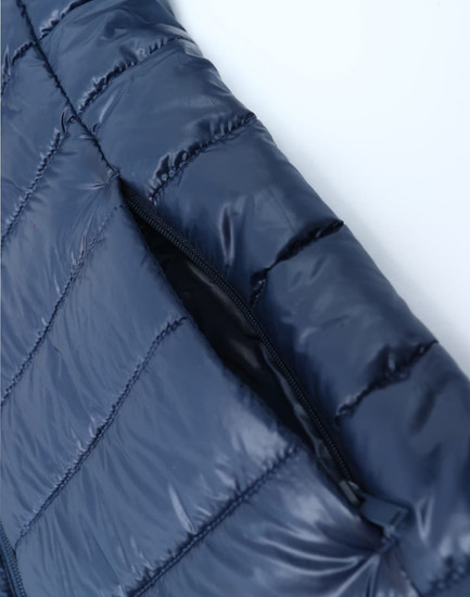 A lightweight, sustainable kids' hooded puffer jacket in navy blue with a zippered opening. Features a logo.