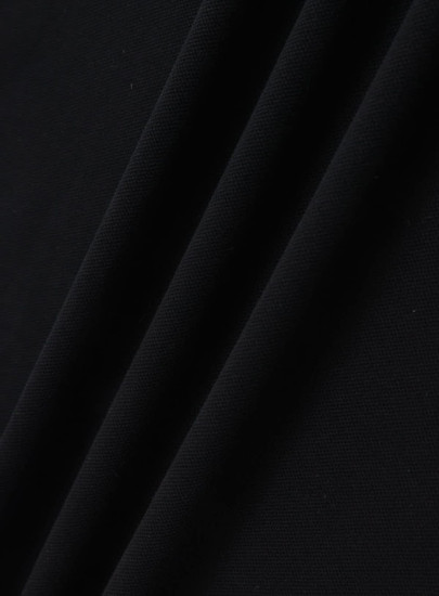 A black ultrafine cotton pique fabric, showcasing a smooth and textured surface. Features a logo or branding.