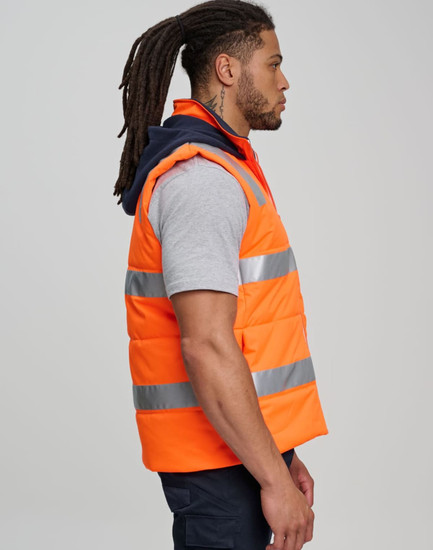 Unisex hi vis hooded puffer vest in bright orange with reflective strips, worn by a model in profile view.