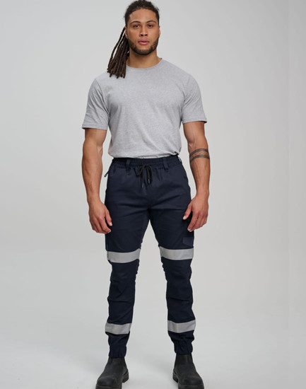 Cotton stretch drill cuffed work pants in navy blue with reflective tapes, worn by a model.