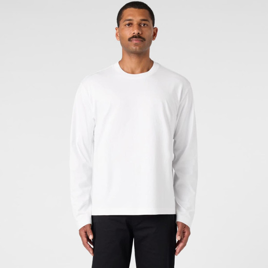A long-sleeve white t-shirt worn by a model against a plain background. The shirt features a logo.