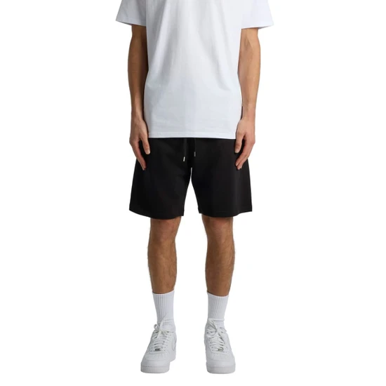Black sports shorts with an elastic waistband, displayed on a model wearing a white t-shirt and white sneakers.