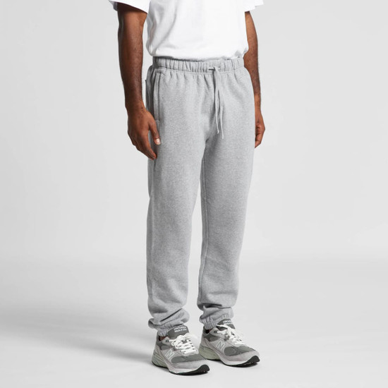 Grey track pants displayed on a person, featuring an elastic waistband and cuffs, with a logo present.