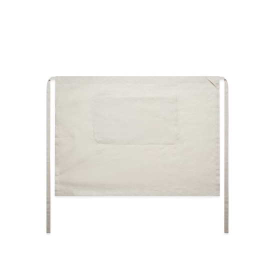 A linen half apron in a light beige colour with ties and a front pocket. The design is simple and functional.