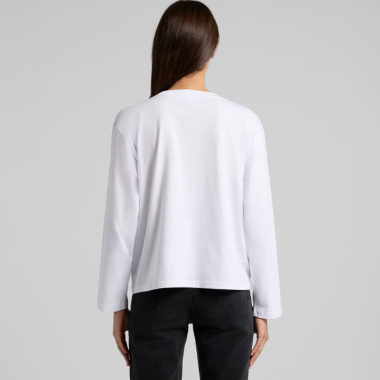 A white long-sleeve t-shirt with a simple design and a logo on the back, styled with black pants.