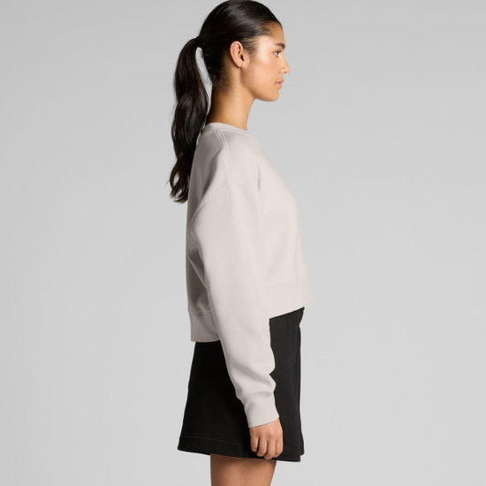 A light beige cropped jumper with a relaxed fit, shown from the side. It features long sleeves and a simple design.