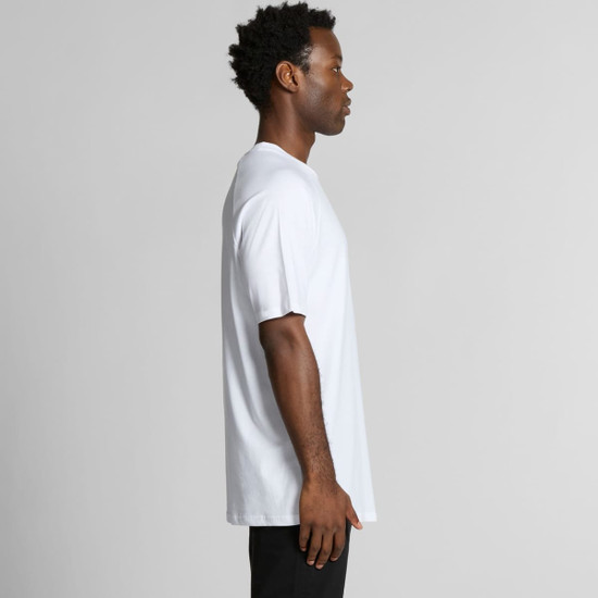 A side view of a man wearing a white Staple Raglan Tee, featuring a relaxed fit and short sleeves.