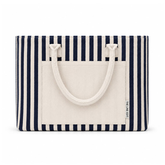 A striped tote bag featuring navy and cream colours, with a flat pocket and sturdy handles. It has a logo.