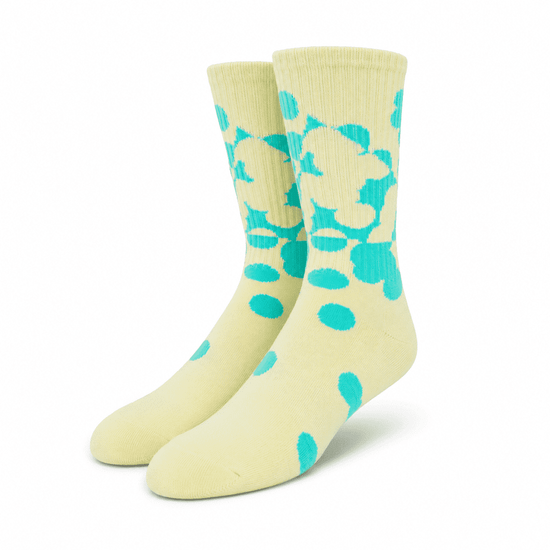 A pair of custom athletic socks in yellow with a turquoise polka dot pattern and a logo.