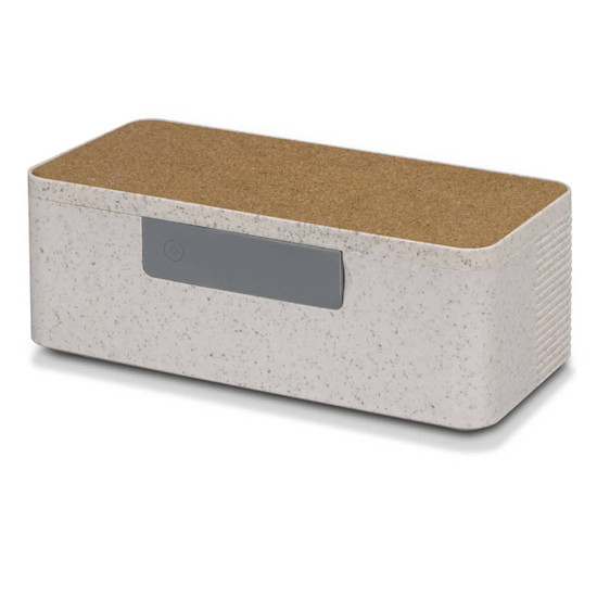 A wireless charger and speaker combination in off-white with a cork top and a grey button. It features a minimalist design.