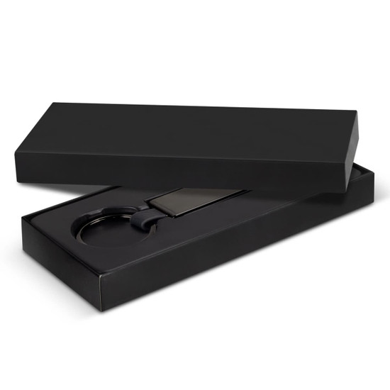 A black gift box containing a black key ring and a rectangular tag. The box is sleek and presents an elegant design.