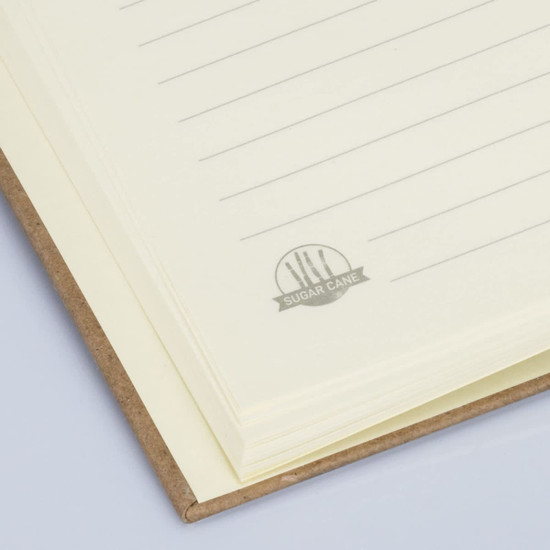 A hard cover notebook with lined cream pages and a subtle branding logo on the inside. The cover is brown.