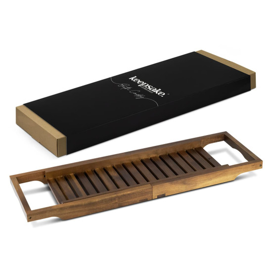 A wooden bath caddy in a warm brown finish, alongside its elegant black packaging with a logo.