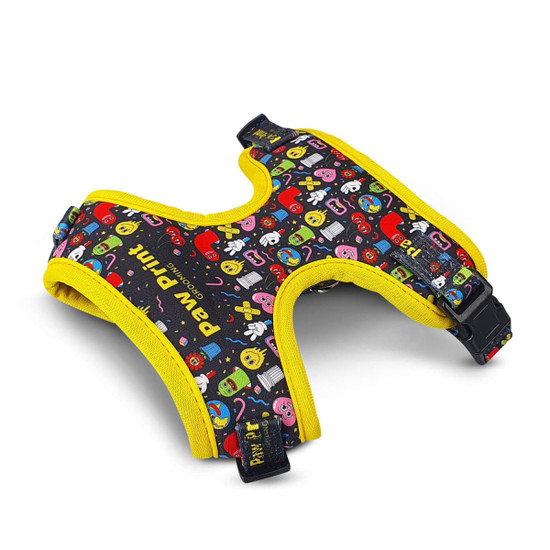 A pet harness in black with colourful patterns and yellow trim, featuring a buckle for secure fastening.