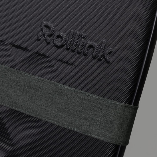 A close-up of a black suitcase featuring a textured surface and an attached dark green strap. It has a logo visible.