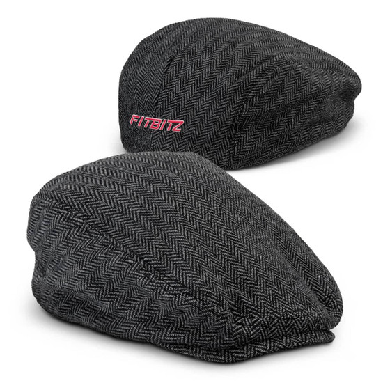 A tweed flat cap in grey herringbone pattern with a branding logo on the side.
