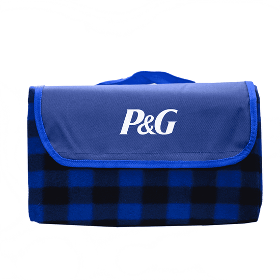 A folded picnic blanket in blue and black checkered pattern, featuring a solid blue flap with a logo.