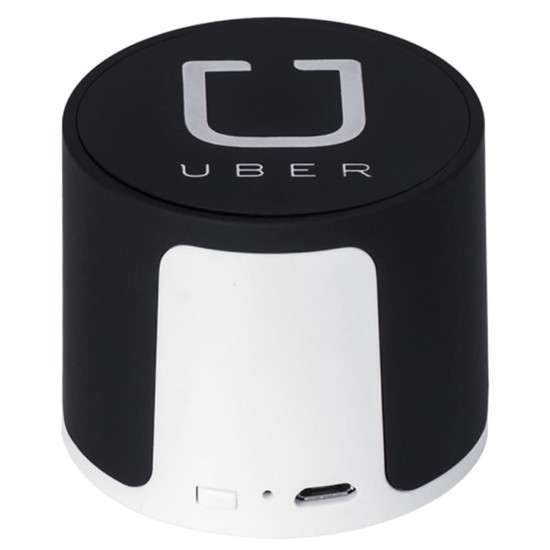 A wireless speaker in black and silver, featuring a logo. Compact design with a USB port.