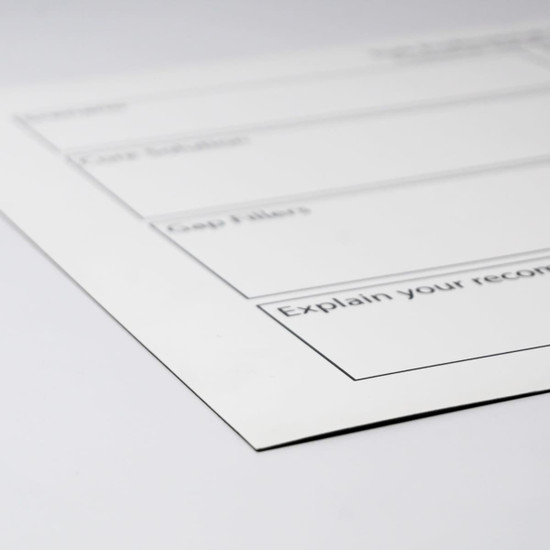 A white magnetic whiteboard with black outline sections for notes, featuring a logo in the corner.