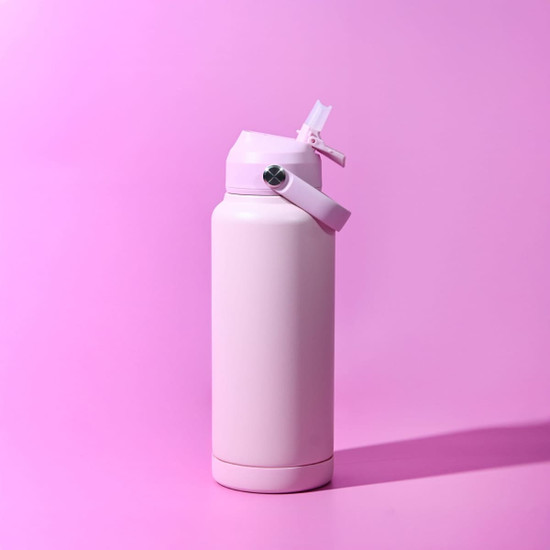A drink bottle in a soft pink colour with a flip-top lid and a strap. It features a logo on the side.