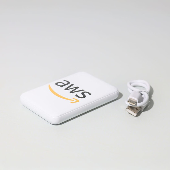 A white powerbank with a logo and a small USB cable beside it.