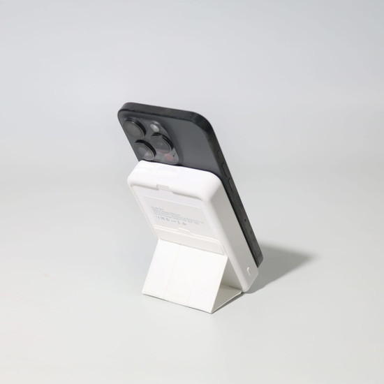 A black and white Turbo 5000mAh wireless charging power bank set on a stand, showcasing its sleek design.