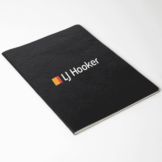 A black Velour DuPont A5 notebook with a textured cover and a logo on the front.