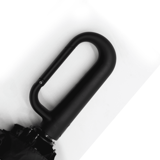 A black foldable umbrella featuring a curved handle and a sleek design. It includes a logo on the handle.