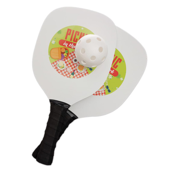 A pickleball set featuring two paddles with colorful picnic-themed graphics and a perforated pickleball.
